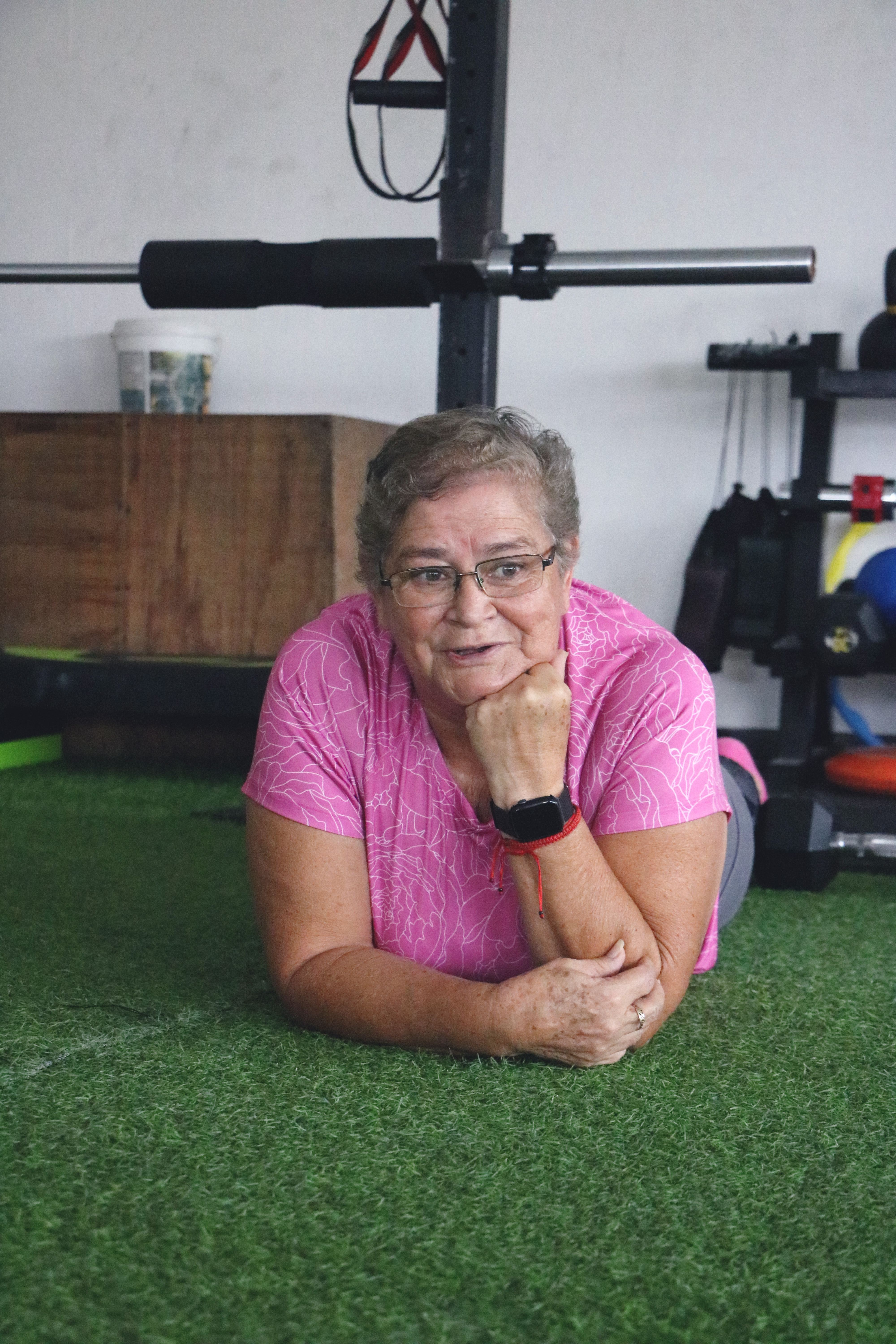 Paciente adulta mayor en posición reflexiva durante su descanso en el gimnasio