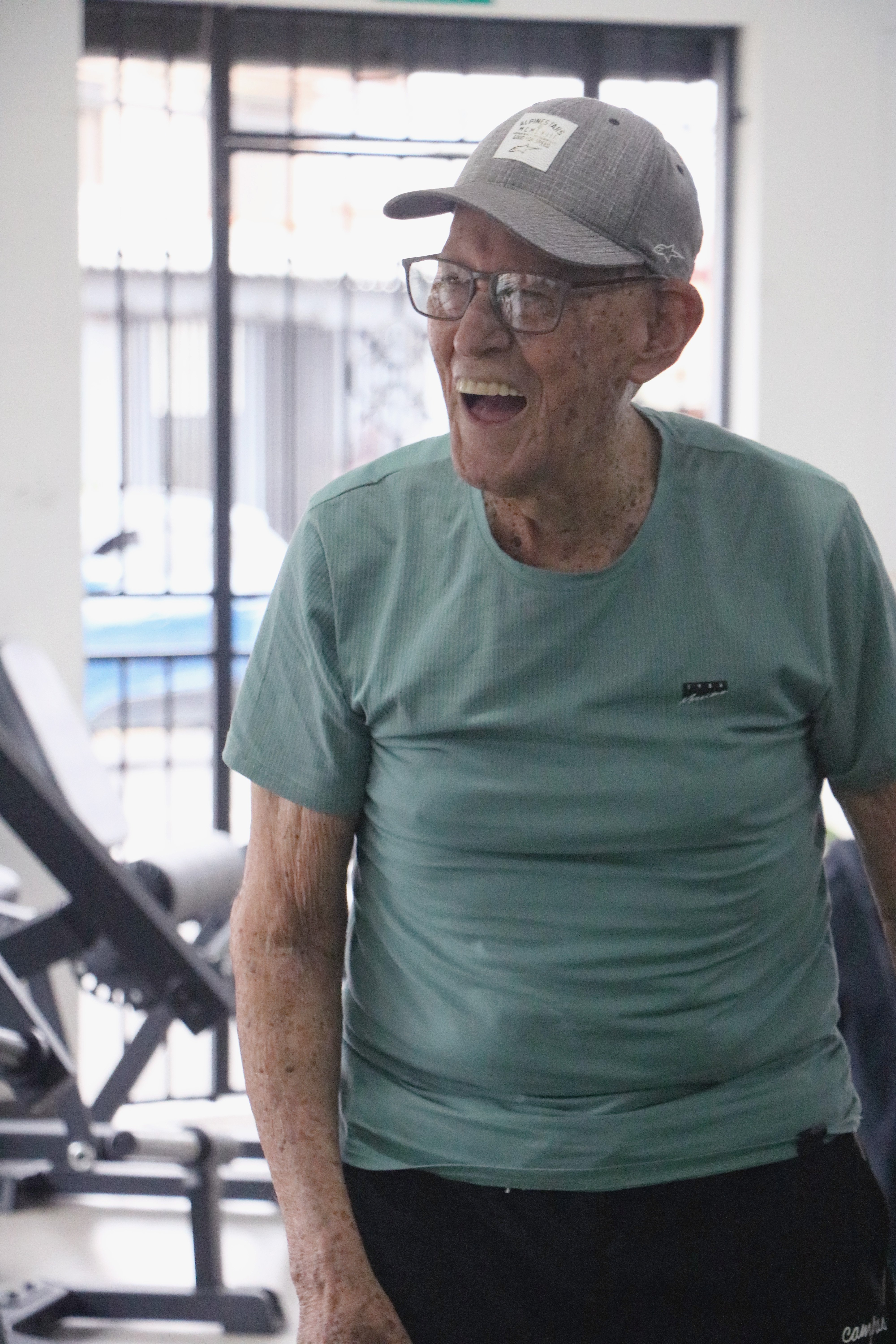 Paciente adulto mayor sonriendo con alegría durante su sesión de ejercicio